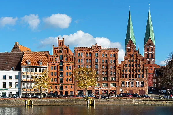Houses on riverfront of Trave river with towers of St. Marienkirche church in background, Lubeck, UNESCO, Schleswig-Holstein, Germany