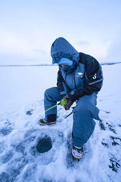 ice fishing on iced lake Tornetrask, Arctic Circle. Abisko National Park, Swedish Lapland, Sweden (MR)