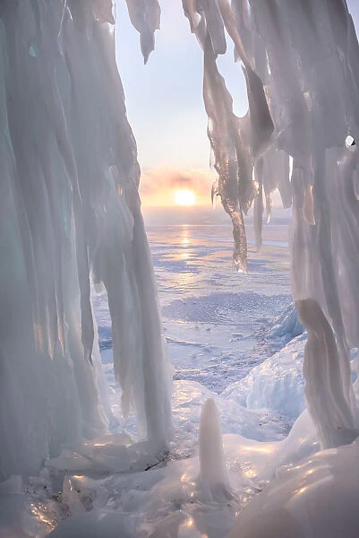 Ice stalactites in a cave at the shore at sunset at lake Baikal, Irkutsk region, Siberia