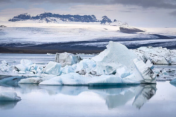 Icebergs floating at Jokulsarlon glacier lagoon against snowcapped mountains, Vatnajokull