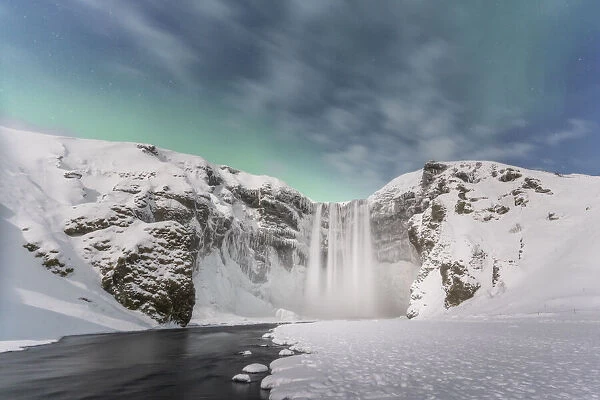 Iceland: the Aurora Borealis is coming over Skogafoss