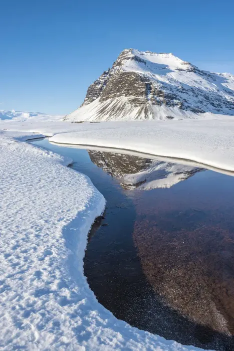 Framed Print : Iceland, Europe. Mountains mirroring in a crystal clear water surrounded by snow