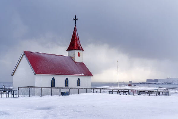 Iceland: the little church of Reynisfjara looking at the storm on the seashore