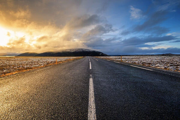 Iceland, Northern Europe. A paved road with dramatic sky