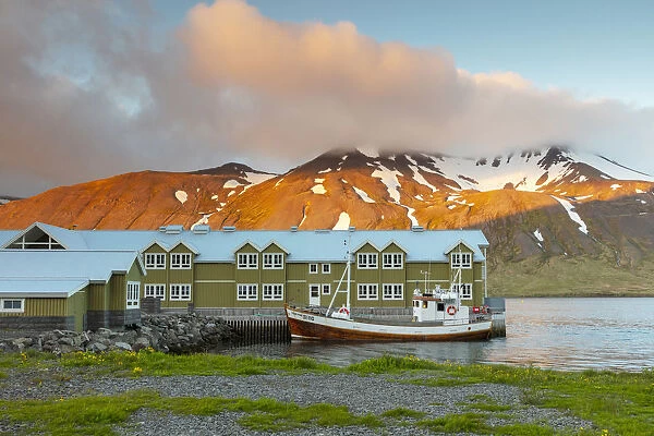 Iceland, Siglufjorður, Siglofjord, Siglo hotel and wooden fishing boat in the midnight sun
