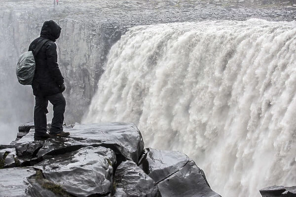 Iceland, a tourist admiring the power of Dettifoss waterfall