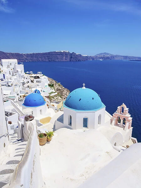 Iconic blue domed churches of Resurrection of the Lord and Saint Spyridon, elevated view, Oia Village, Santorini or Thira Island, Cyclades, Greece