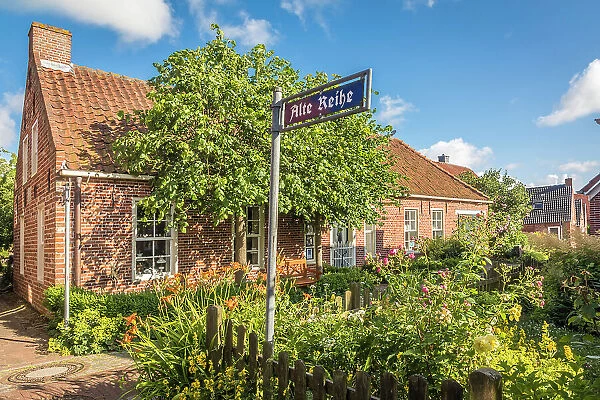 Idyllic cottage garden in the village of Pilsum, Krummhoern, East Frisia, Lower Saxony, Germany