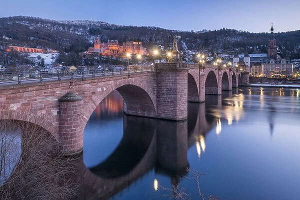 Illuminated Heidelberg castle and Alte Brucke (Old Bridge) in winter at night