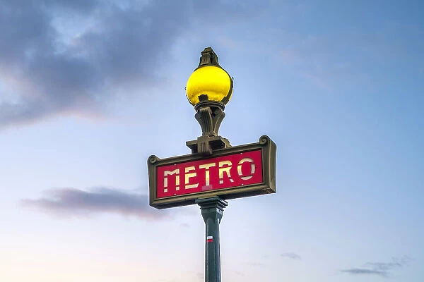 Illuminated Metro sign at sunrise, Paris, Ale-de-France, France