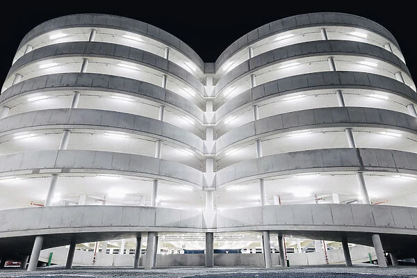 Illuminated parking garage concrete structure at night, Hamburg, Germany