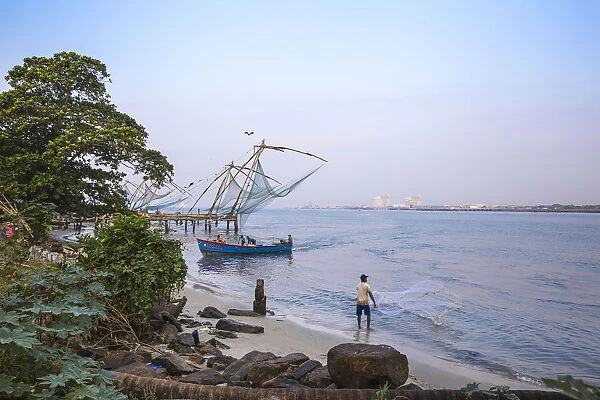 India, Kerala, Cochin - Kochi, Vipin Island, Man fishing infront of Chinese fishing nets