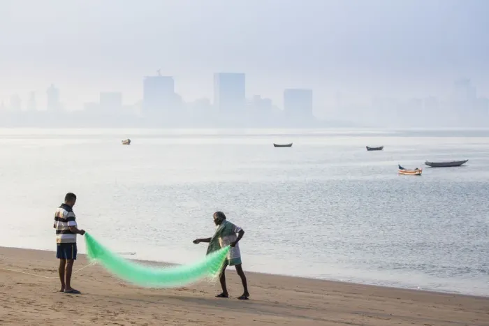 Framed Print : India, Maharashtra, Mumbai, Chowpatty, Men with fishing net on beach