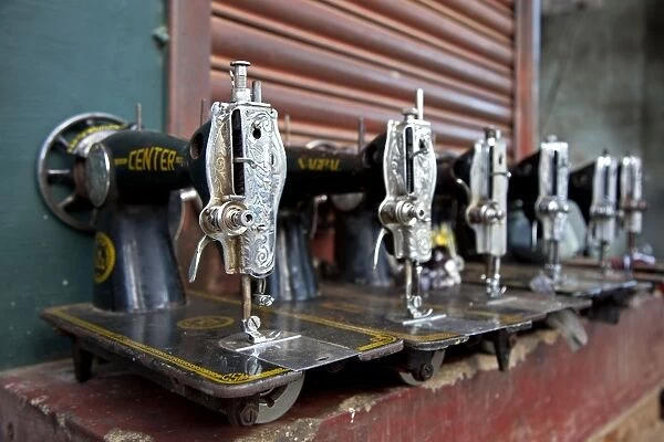 India, Mysore. Recently-repaired sewing machines lined up outside a sewing-machine repair shop in Mysore