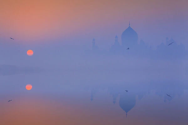 India, Taj Mahal memorial on a foggy morning with the sun rising in the background