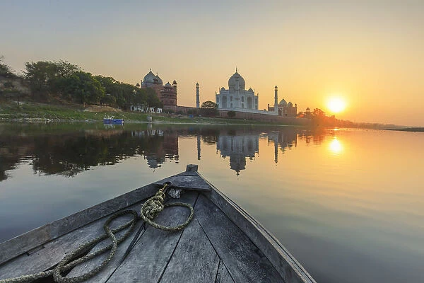 India, view of the Taj Mahal reflecting in the Yamuna river at sunset from a wooden boat