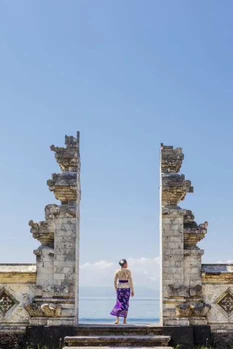 Framed Print : Indonesia, Bali, Candidasa. A local young woman standing in the gateway to the Pura Framed Print : Indonesia, Bali, Candidasa. A local young woman standing in the gateway to the Pura