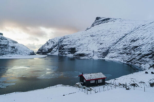 An isolated cottage in fronf of the lagoon in Saksun. Streymoy, Faroe Islands