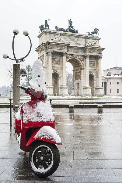 Italian vespa and Arch of Peace with snow. Milan, Lombardy, Italy