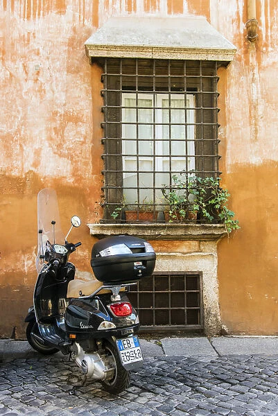 Italian Vespa scooter parked in a cobblestone street of Rome, Lazio, Italy
