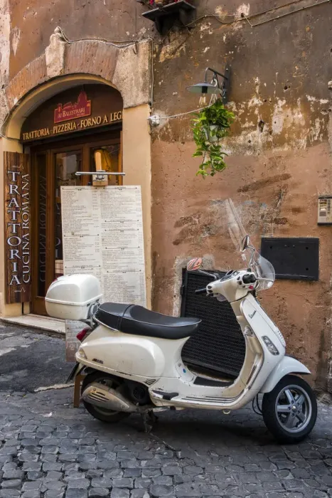 Framed Print : Italian Vespa scooter parked outside a trattoria restaurant in a cobblestone street