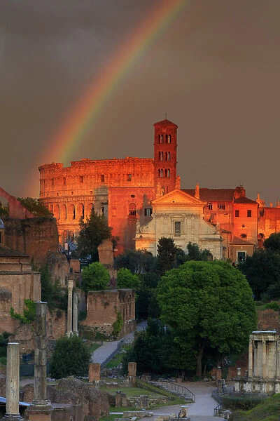 Italy, Rome, rainbow over Colosseum and Roman Forum at sunset