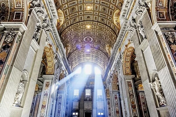 Italy, Rome, St. Peter Basilica interior with sun lights penetrating through the
