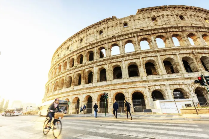 Framed Print : Italy, Rome, a woman riding a bike Colosseum and Roman Forum at sunrise