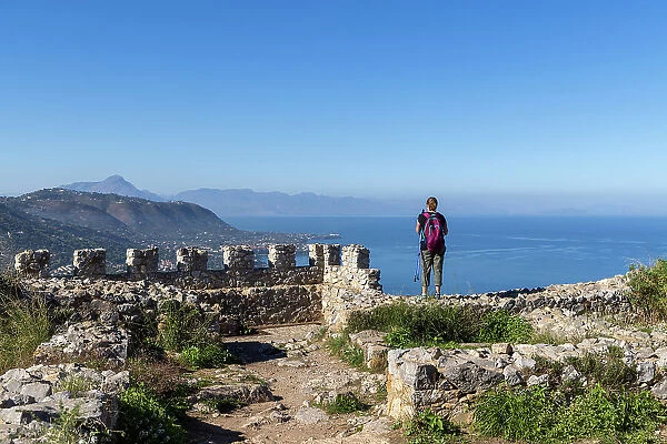 Italy, Sicily, Cefalu, a hiker admires the view of the coastline around Cefalu
