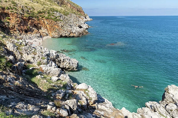 Italy, Sicily, Riserva Naturale Orientata dello Zingaro, Zingaro nature reserve, a man swims in the clear water