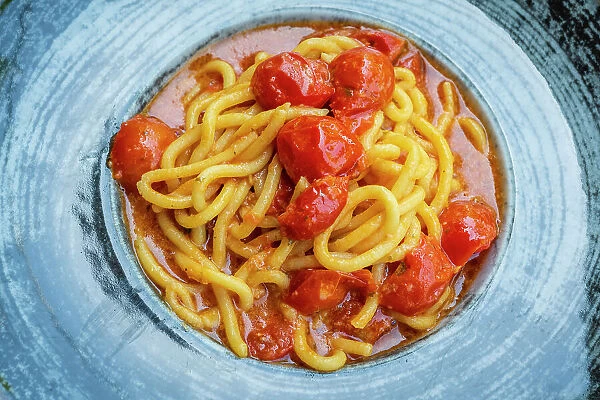 Italy, Umbria. A plate of Umbricelli handmade pasta with fresh tomato sugo
