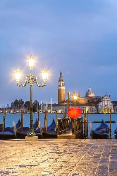 Italy, Veneto, Venice. Woman with red umbrella on Riva degli Schiavoni at dawn (MR)