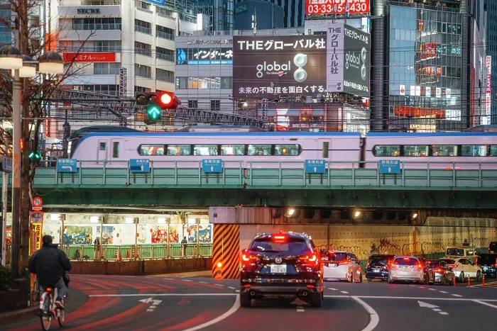 Framed Print : Japan, Tokyo, Train passing over road with cars and cyclist at dusk