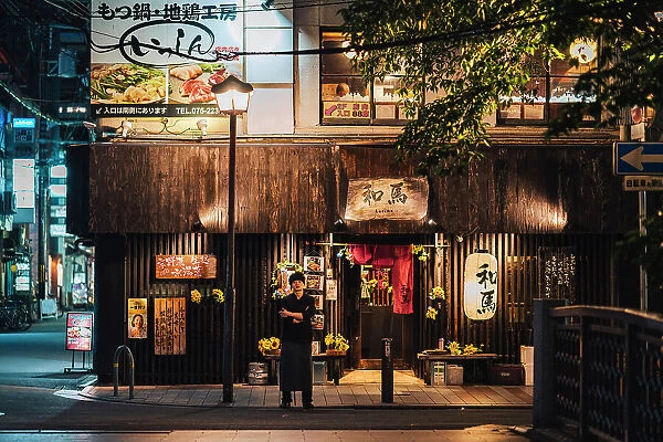 Japanese chef in front of a restaurant at night in Kyoto, Japan