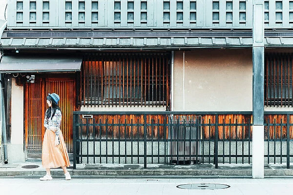 Japanese girl in front of a typical traditional building in Kyoto