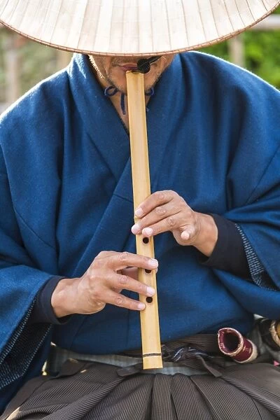 Japanese man playing traditional wooden flute, Kyoto, Japan