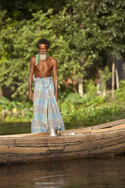 Jessore, Bangladesh. A traditional boatman transports milk to market