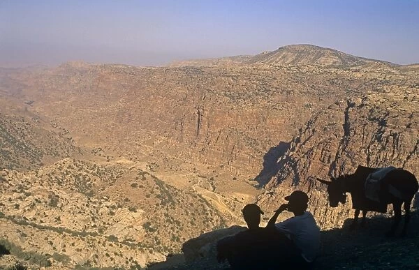 Jordan, Dana Biosphere Reserve. Dana village youths gaze over the spectacular lip of Wadi Dana towards