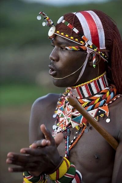 Kenya, Laikipia, Ol Malo. A Samburu warrior sings and claps during a dance