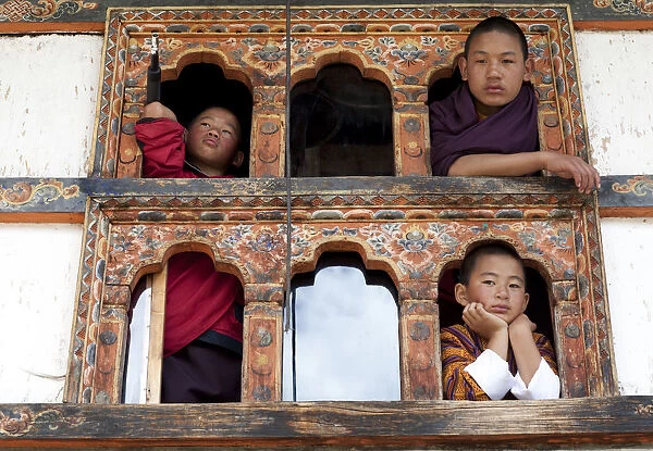 Kids looking out the window of a monastery in Bhutan