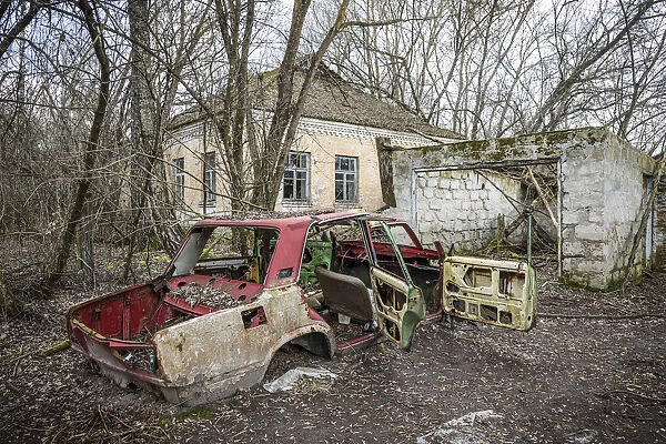 Lada car and house in an Abandoned village inside the Chernobyl Exclusion Zone, Ukraine