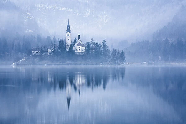 Lake Bled at dawn in winter with Assumption of Marys Pilgrimage Church, Slovenia