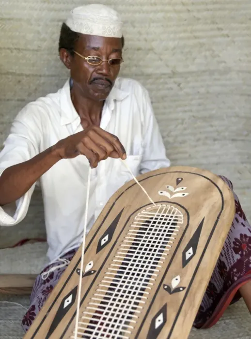 Framed Print : A Lamu man strings the back of a traditional Lamu-style Framed Print : A Lamu man strings the back of a traditional Lamu-style