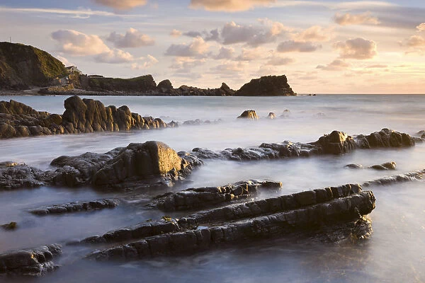 Late evening sunshine glistens on the wet rocks at Hartland Quay, North Devon, England