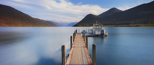 A little boat and a jetty in the Rotoroa lake, part of the Nelson lakes in New Zealand