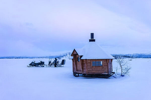 little wooden hut on the iced lake Tornetrask, Arctic Circle. Abisko National Park, Swedish Lapland, Sweden