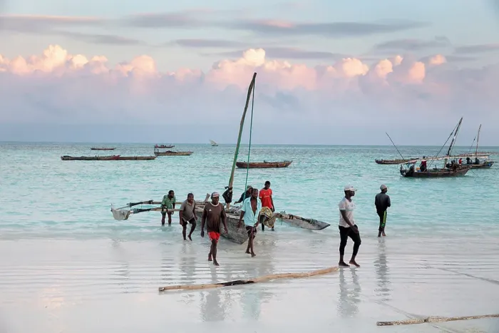Framed Print : Local fishermen carrying their dhow up the beach, Nungwi, Zanzibar, Tanzania