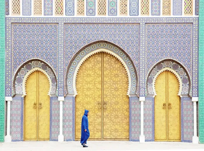 Framed Print : Local man wearing blue Djellaba walking past the golden doors of the Royal Palace, Fes, Morocco Framed Print : Local man wearing blue Djellaba walking past the golden doors of the Royal Palace, Fes, Morocco