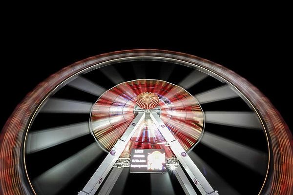 Long exposure of illuminated ferris wheel at Hamburger DOM funfair at night, St. Pauli