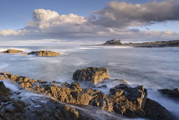 Framed Print : Looking across rocky ledges to Bamburgh Castle, Northumberland, England Framed Print : Looking across rocky ledges to Bamburgh Castle, Northumberland, England
